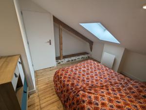 een slaapkamer met een bed en een dakraam bij Le Nid de Mazerolles in Sucé