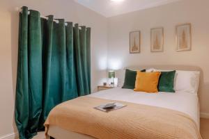 a bedroom with a bed with green curtains at Mayfield Two - Central Harrogate Apartment in Harrogate