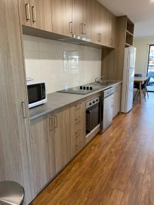 a kitchen with wooden cabinets and stainless steel appliances at Wedderburn Caravan Park in Wedderburn