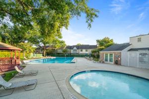 a swimming pool with lounge chairs and a house at Townhome - Convenient Location in Houston