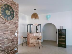 ein Zimmer mit zwei Stühlen und einer Uhr an der Wand in der Unterkunft Maison neuve 200m2 climatisée, proche de la plage et des commerces in Audenge