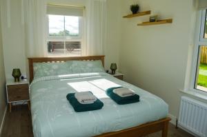 a bedroom with a bed with two towels on it at Cuilcagh Croft - Fermanagh Lakelands in Enniskillen