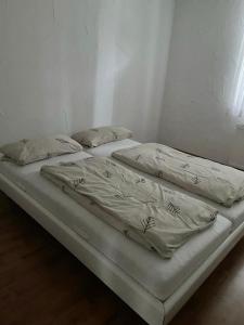 2 łóżka z białą pościelą i poduszkami w pokoju w obiekcie Apartment Lara w mieście Friedrichshafen