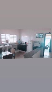 - une cuisine avec un comptoir et un réfrigérateur dans la chambre dans l'établissement Casa da Taty, à Tatuí