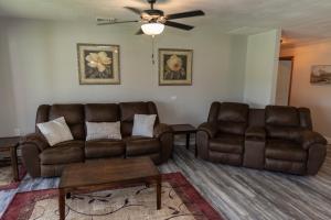 a living room with two brown leather couches and a table at Stony Fork Inn in Wellsboro