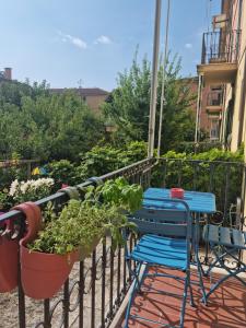 a table and chairs on a balcony with a plant at Alemanni54 - Apartment in Bologna