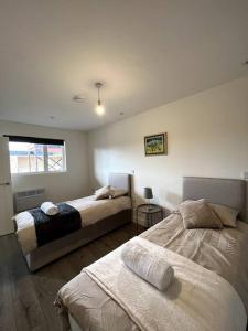 um quarto com 2 camas e uma janela em Spacious One Bedroom Apartment em Hemel Hempstead