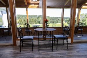 uma mesa e cadeiras num quarto com uma grande janela em Stony Fork Inn em Wellsboro