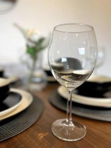 um copo de vinho sentado numa mesa de madeira em Spacious One Bedroom Apartment em Hemel Hempstead