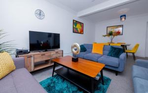 a living room with a couch and a tv at Wandle Grove House in Birmingham
