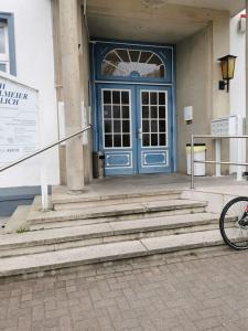 a bike parked in front of a building with a blue door at Ferienwohnung 303 am Kasinopark in Georgsmarienhütte