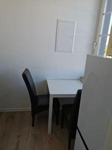 un escritorio blanco con una silla negra y una pared blanca en Ferienwohnung 303 am Kasinopark, en Georgsmarienhütte