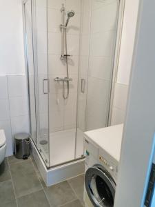 een douche in een badkamer met een wasmachine bij Ferienwohnung 303 am Kasinopark in Georgsmarienhütte