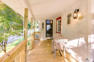 een tiny house met een veranda met een tafel en stoelen bij Historic Boonsboro Vacation Rental with Grill in Sharpsburg