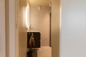 een badkamer met een douche, een wastafel en een spiegel bij Elegant apartment in city centre in Tromsø