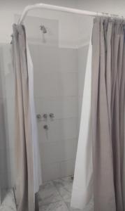 ein Badezimmer mit Duschvorhang und Badewanne in der Unterkunft LA MAMA in Mercedes