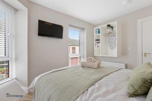 ein weißes Schlafzimmer mit einem Bett und einem Flachbild-TV in der Unterkunft Luxury Apartment - Roe Getaway Limavady in Limavady