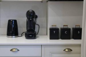 a black blender sitting on a counter with two black containers at Lavish London Stay Near Wembley Stadium in London
