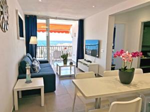 a living room with a blue couch and a table at Appartement standing Vue panoramique OceanSight Beach 250m in Los Cristianos