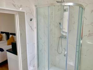 a bathroom with a shower with a glass door at London Studio Apartments Close to Station NP2 in London