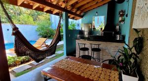 a room with a porch with a hammock and a kitchen at Casa Cica in Ubatuba