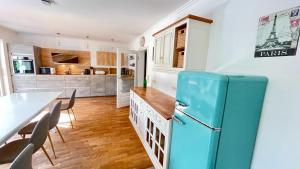 a kitchen with a blue refrigerator and a table at Unterkunft für Familien und Gruppen in Seenähe mit Garten in Hannover