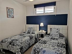 a bedroom with two beds and a window at Los Cristianos Achacay Appartement standing Vue panoramique in Los Cristianos