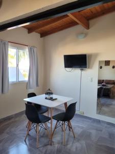 a dining room with a white table and chairs at Jucaso Departamentos in San Pedro