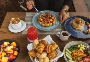 a wooden table with plates of food on it at Hotel Estelar Miraflores in Lima