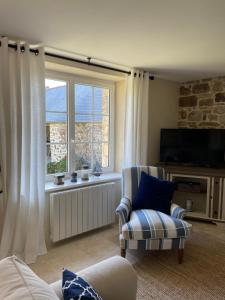 un soggiorno con sedia e finestra di Les Cottages du Manoir, Jacuzzi -Crozon a Crozon