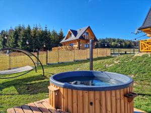 a hot tub in a yard with a house at NOVAK CHALET domki z balią Krynica Zdrój in Krynica Zdrój
