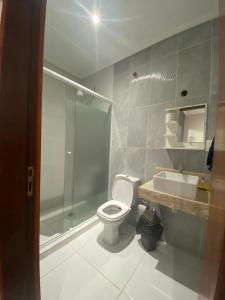 y baño con ducha, aseo y lavamanos. en Apartamento Espanha, en Ciudad del Este