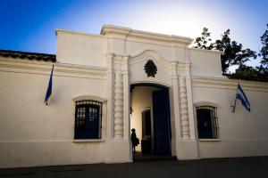 a woman standing in front of a white building at Departamento frente a la CASA HISTÓRICA DE TUCUMAN in San Miguel de Tucumán