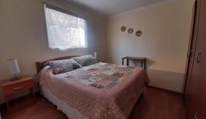 um quarto com uma cama e uma janela em Apart Maxi em Arica