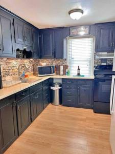 uma cozinha com armários azuis, um lavatório e um micro-ondas em FDL’s Finest, w/ Massage shower em Fond du Lac