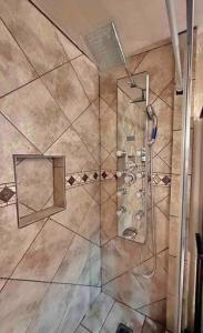 um chuveiro com uma porta de vidro e um espelho em FDL’s Finest, w/ Massage shower em Fond du Lac