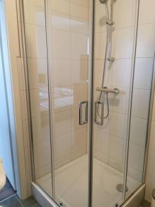 a shower with a glass door in a bathroom at Ferienwohnung 305 am Kasinopark in Georgsmarienhütte