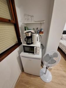 małą kuchnię z kuchenką mikrofalową i krzesłem w obiekcie habitacion con baño privado en un piso con familia w mieście Santa Cruz de la Palma +10 zdjęć
