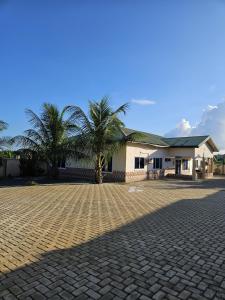 uma entrada de tijolos em frente a uma casa com palmeiras em My Place Guest House em Ho