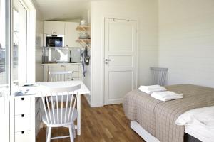 a small bedroom with a bed and a kitchen at Kajkanten Vrångö in Vrångö