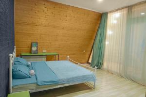 a bedroom with a bed and a wooden wall at Alagi Cottage at Bazaleti lake in Grigolaantkari