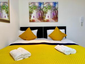 a bedroom with a yellow bed with two pillows at London Studio Apartments Close to Station NP5 in London