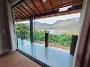 um quarto com vista para um rio e montanhas em Casa do Lago Lapinha da Serra em Santana do Riacho