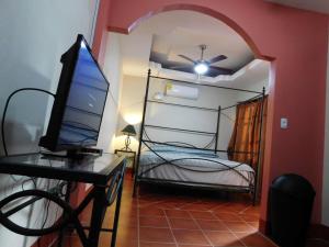 Habitación con cama y escritorio con ordenador. en Casa El Caimito en Granada