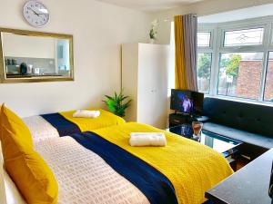 a bedroom with two beds with yellow and blue sheets at London Studio Apartments Close to Station NP6 in London