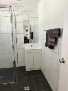 uma casa de banho branca com um lavatório e um chuveiro em Atherton Holiday Park em Atherton