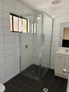 a shower with a glass door in a bathroom at Atherton Holiday Park in Atherton