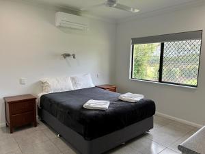 a bedroom with a bed with two towels on it at Atherton Holiday Park in Atherton