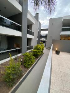 una vista exterior de un edificio con plantas en Departamento nuevo con seguridad y pileta ,en villa allende a 15 del centro de Córdoba en Villa Allende