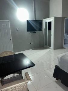 a living room with a table and a tv on the wall at Oak Villa Montego Bay 2 Entire in Montego Bay